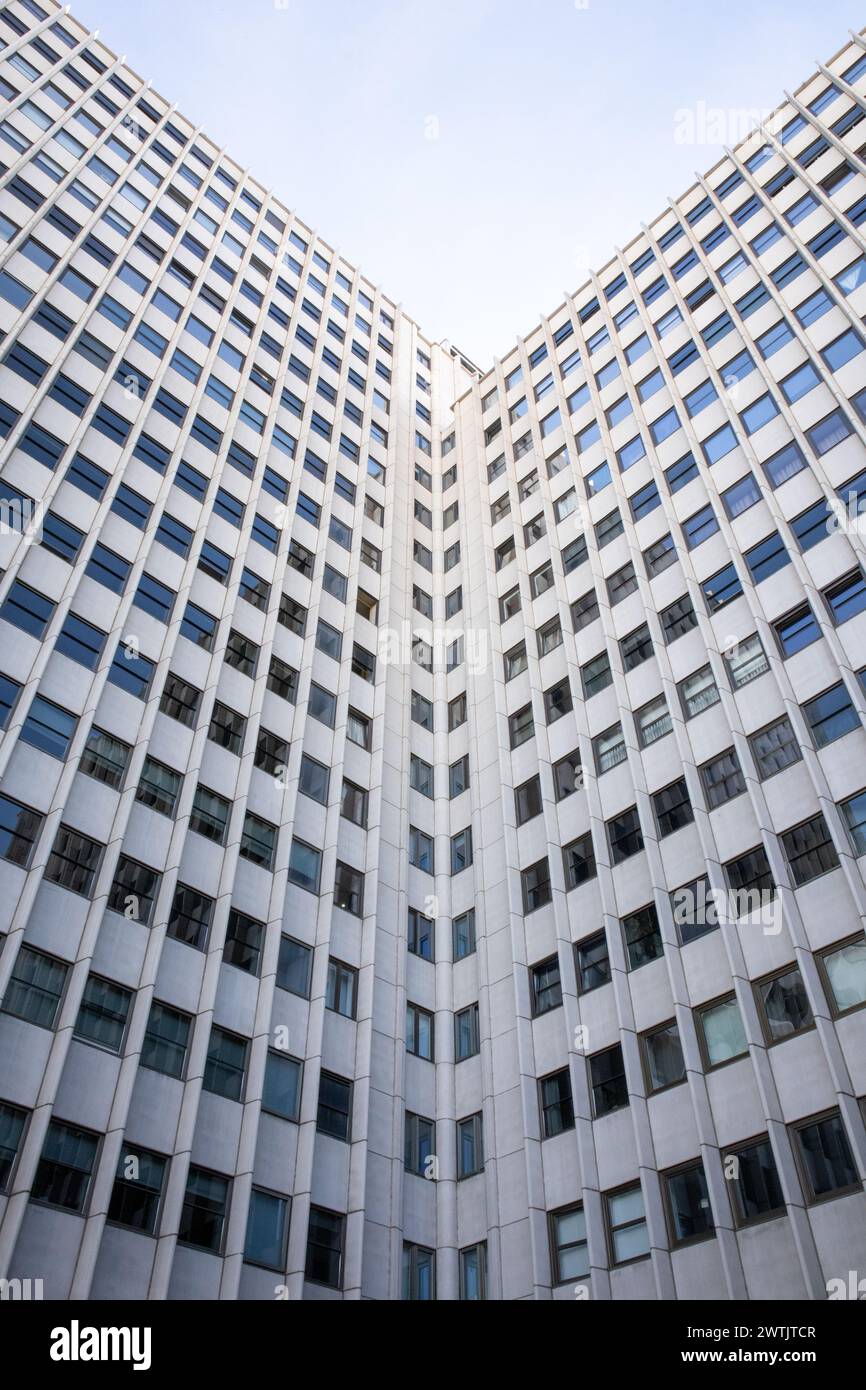 Facciata simmetrica di un alto edificio con file di finestre, che cattura l'architettura urbana in un design minimalista Foto Stock