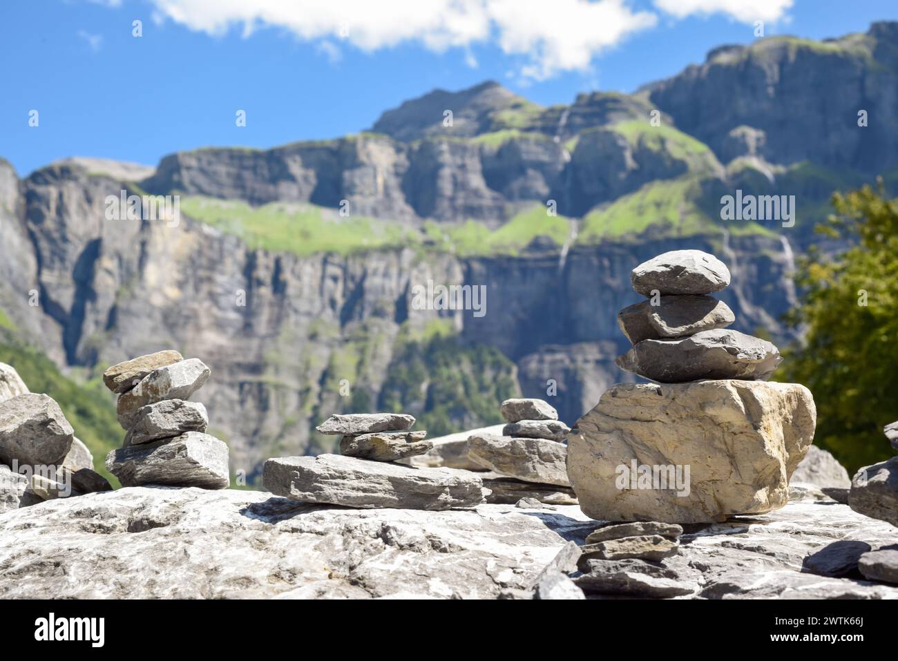 Pila di rocce bilanciate che simboleggiano pace e consapevolezza su un lussureggiante paesaggio montano Foto Stock