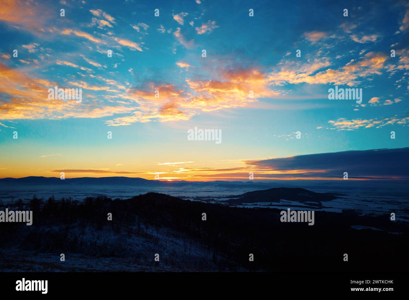 Tramonto in montagna. Il sole si tuffa dietro le cime delle montagne con luce dorata. Splendido paesaggio naturale Foto Stock