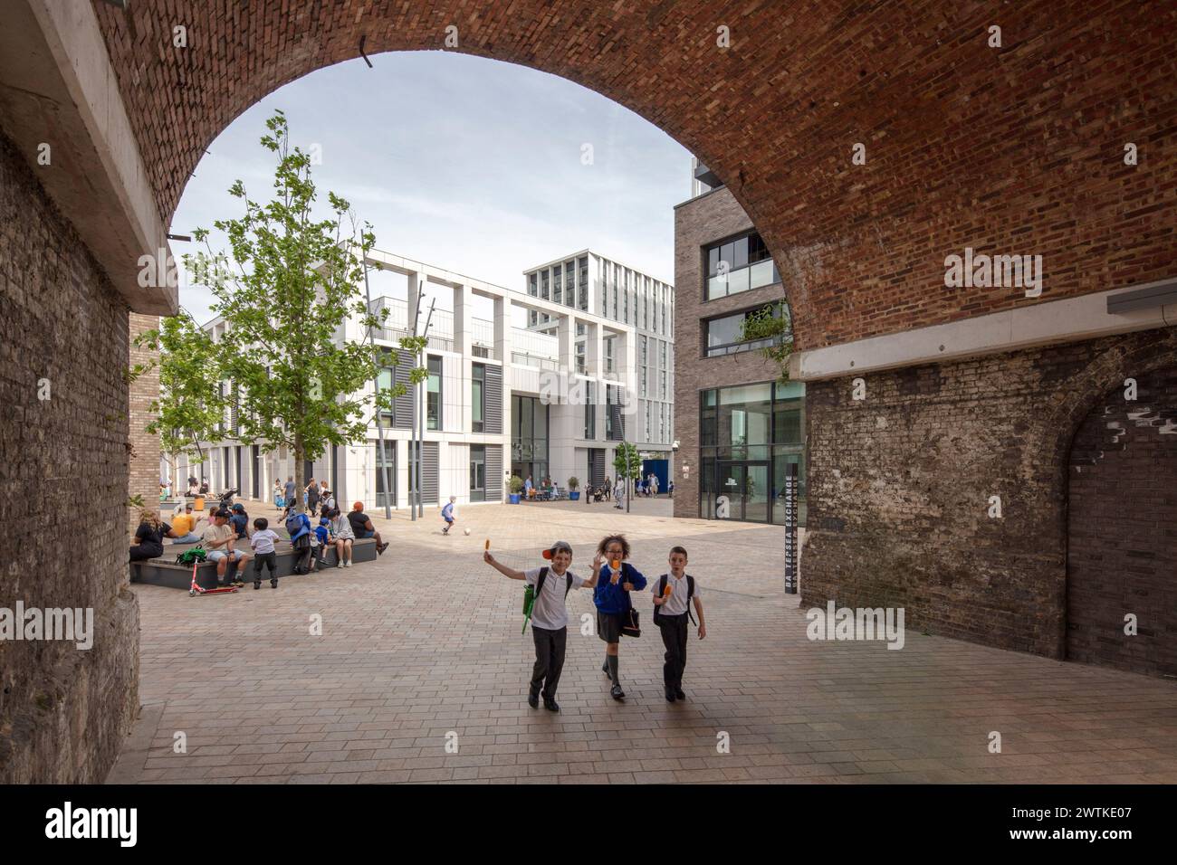 Guardando attraverso l'area pedonale fuori dalla scuola di St Marys attraverso gli archi ferroviari. Battersea Exchange e St Mary's RC Primary School, Londra, Foto Stock