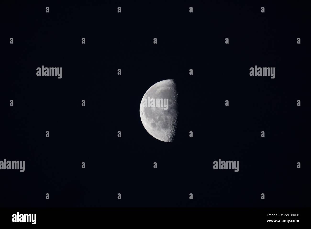 La mezza luna nel cielo notturno senza nuvole Foto Stock