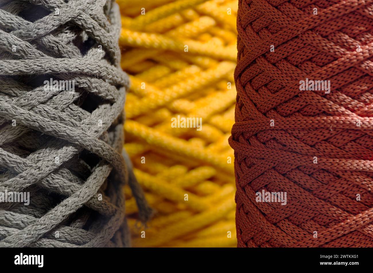 Inserti assortiti di cordone sintetico intrecciato multicolore, sfondo astratto dell'industria tessile Foto Stock