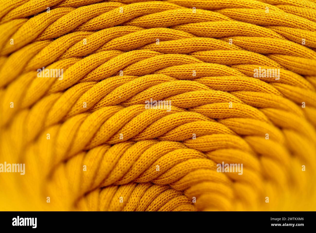 Spilla di cordone sintetico intrecciato giallo, primo piano, messa a fuoco selettiva, background astratto del settore tessile Foto Stock