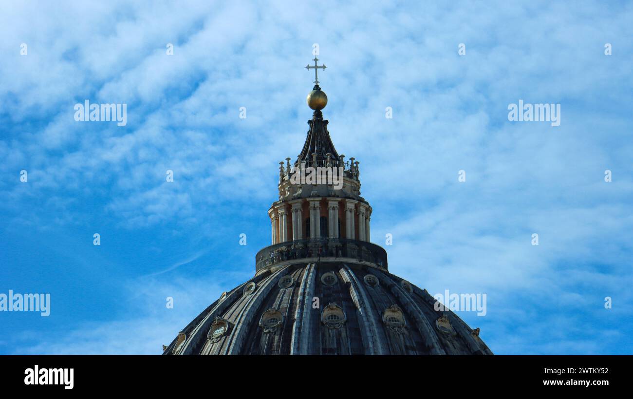 Vaticano, Italia; 10-22-2023. Vista dettagliata della sommità della cupola di St. Basilica di Pietro in Vaticano, cielo blu e nuvole bianche nel backgrou Foto Stock