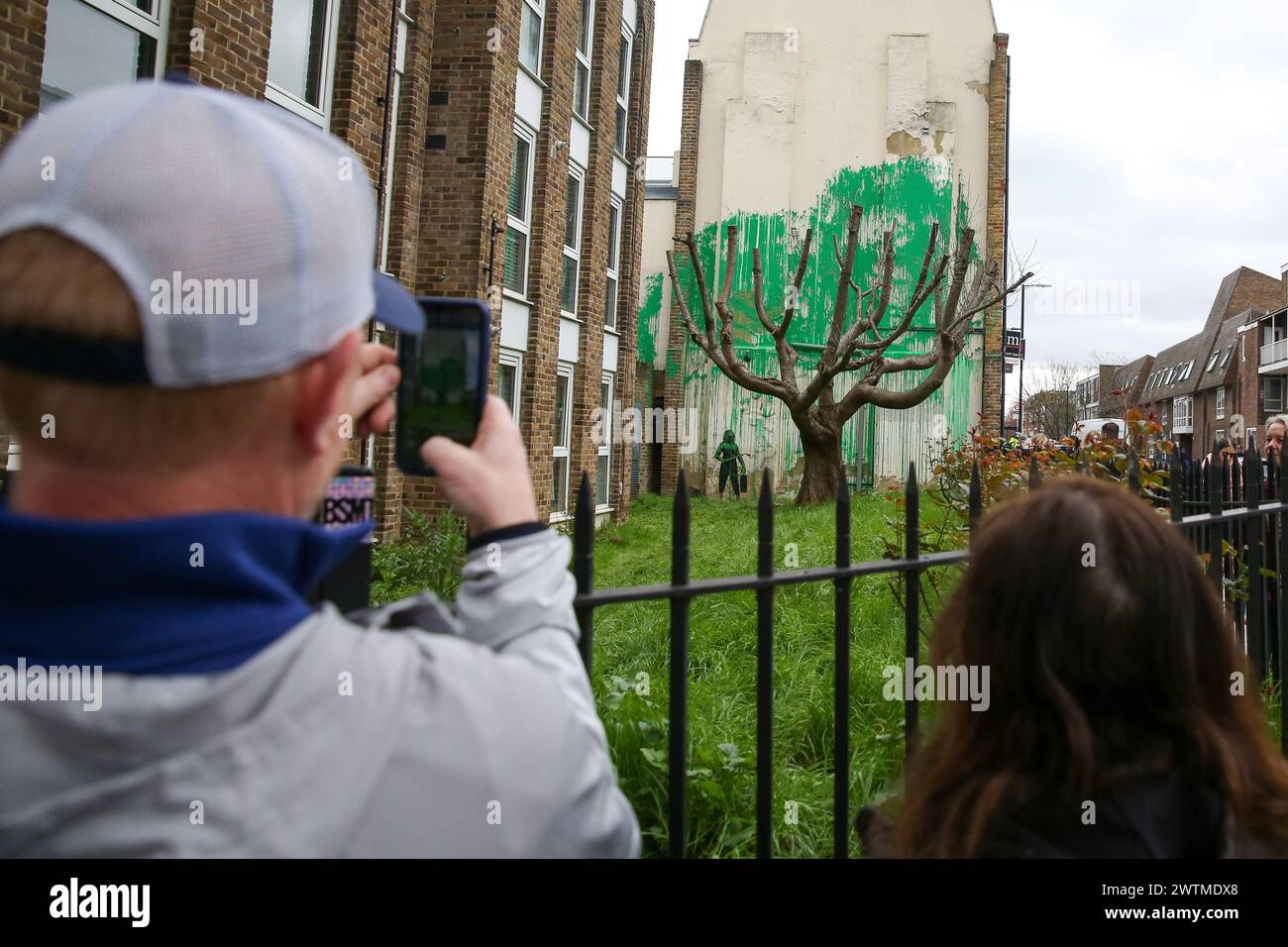 Londra, Regno Unito. 18 marzo 2024. Un uomo scatta fotografie dell'arte Banksy a Finsbury Park. Il murale con graffiti è apparso su un muro accanto ad un albero su Hornsey Road, a nord di Londra. (Foto di Steve Taylor/SOPA Images/Sipa USA) credito: SIPA USA/Alamy Live News Foto Stock