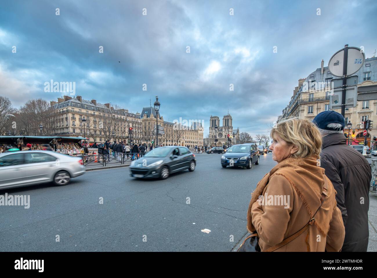 Una coppia in piedi in strada con Notre Dame sullo sfondo in Quai Saint Michel Street a Parigi, Francia. Foto Stock