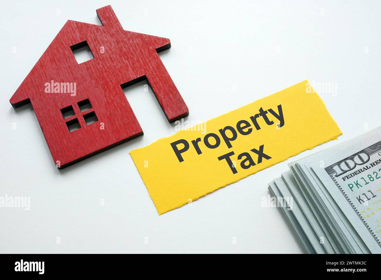 Una striscia di tasse sulla proprietà cartacea, un modello di casa e denaro. Foto Stock