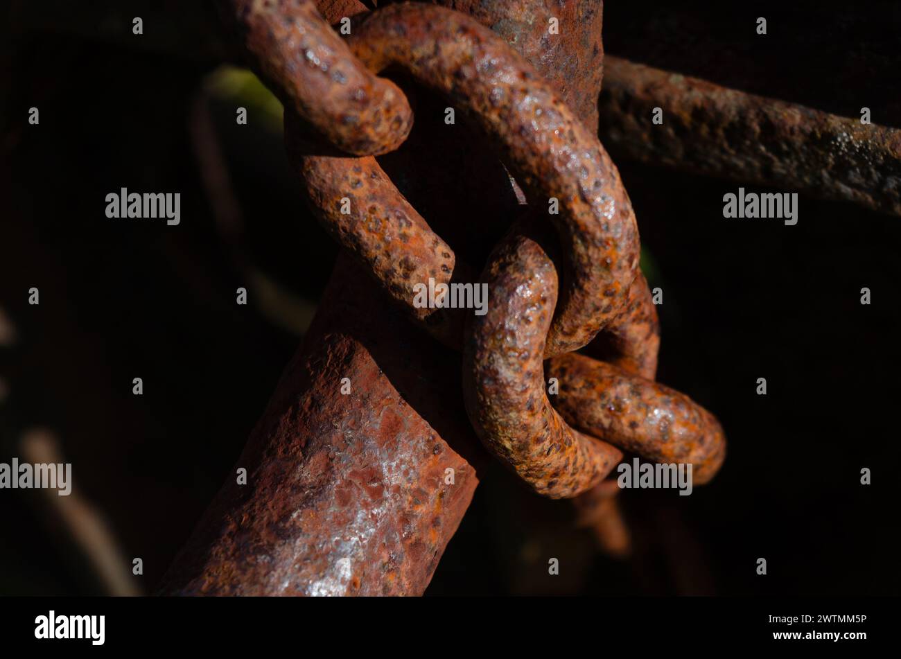 Primo piano di una catena arrugginita che fissa una vecchia macchina per motivi di sicurezza Foto Stock