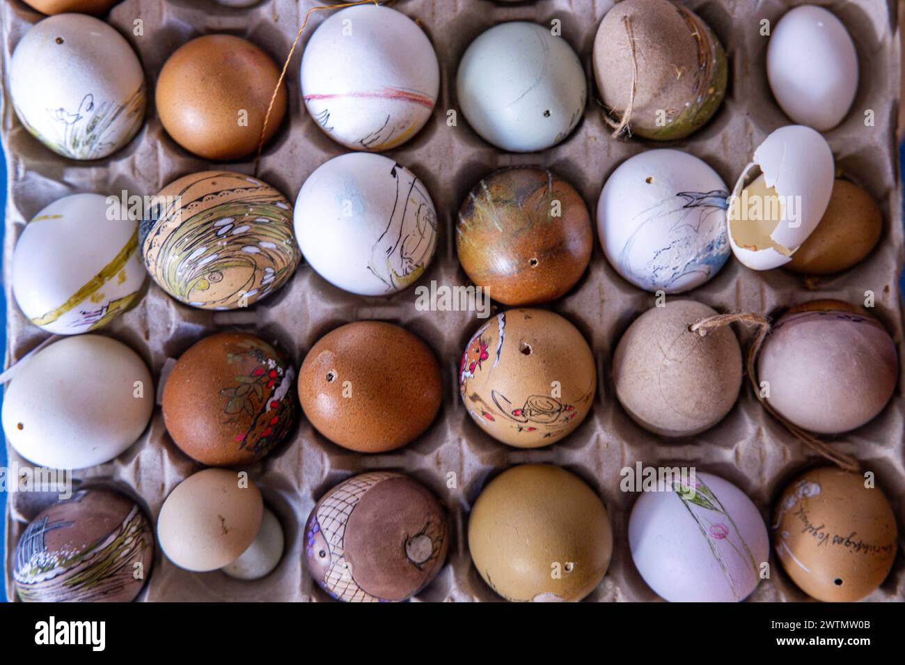 Schwerin, Germania. 18 marzo 2024. Varie uova si trovano nella sala di pittura dell'artista uovo Ines Höfs. Prima di Pasqua, la richiesta di motivi colorati sulle uova è particolarmente elevata. Dalle uova di piccione alle uova di struzzo vuote, tutto si trasforma in decorazioni pasquali nel piccolo studio di pittura. Ines Höfs dipinge le uova tutto l'anno ed espone le opere d'arte in musei o le vende nel suo negozio online o nei mercati. Crediti: Jens Büttner/dpa/Alamy Live News Foto Stock