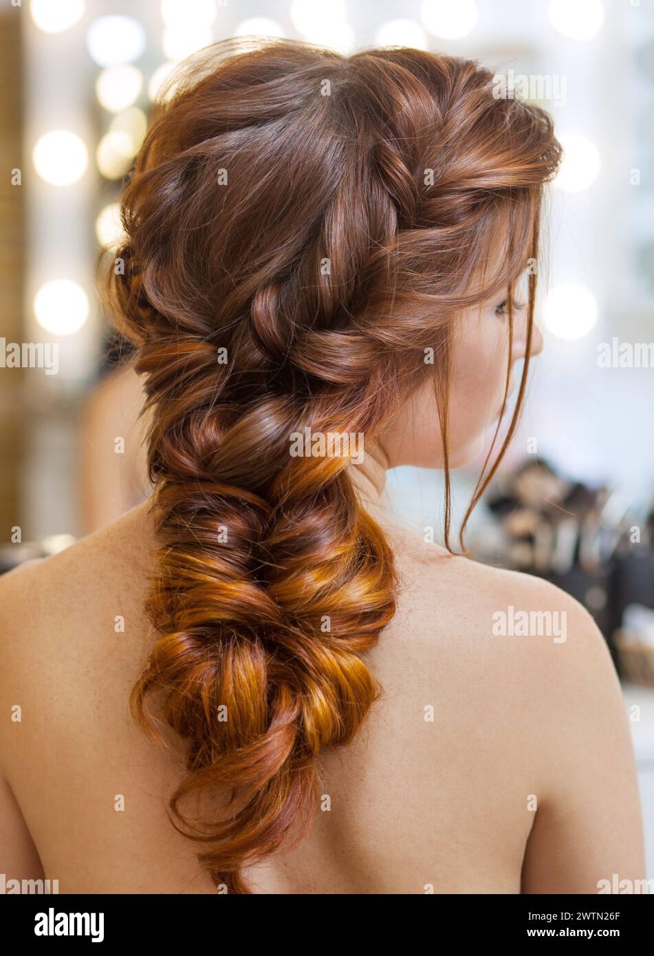 Bella ragazza dai capelli rossi con capelli lunghi in un salone di bellezza. Cura professionale dei capelli e creazione di acconciature. Foto Stock