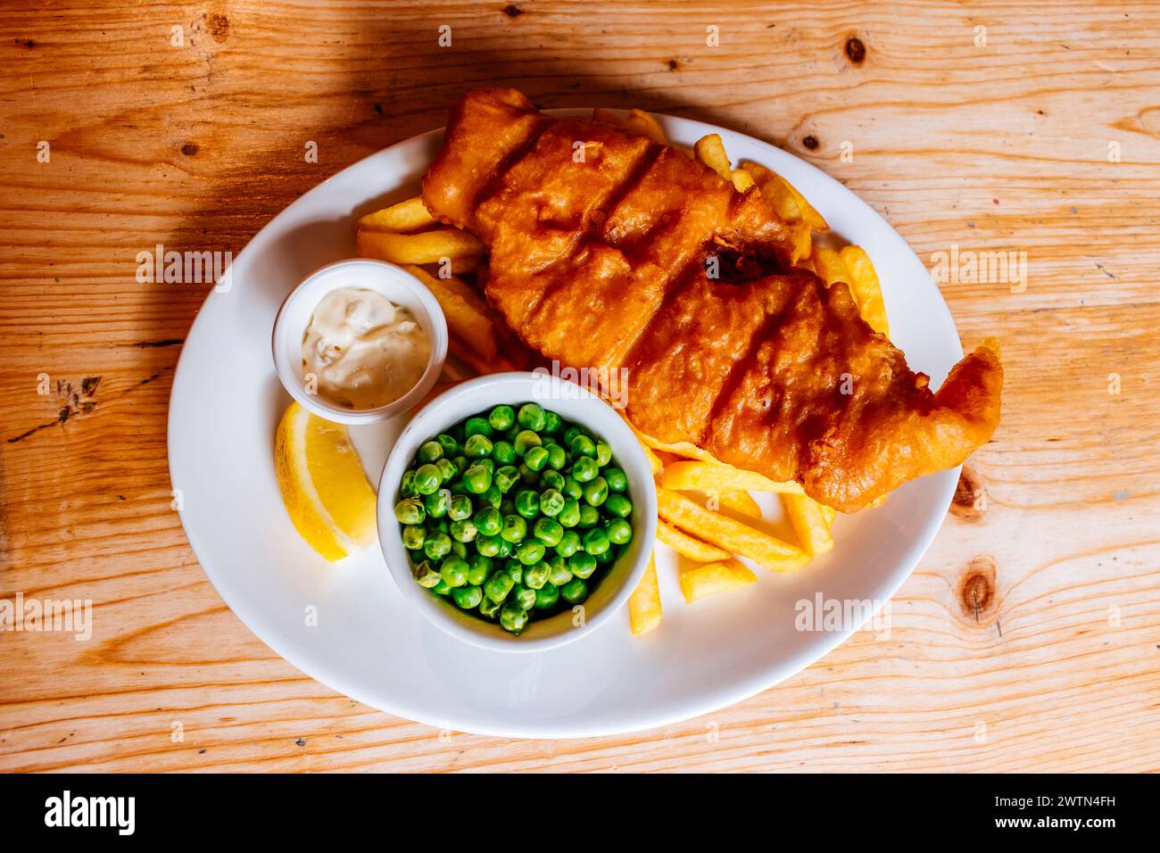 Fish and chips è un piatto caldo composto da pesce fritto in pastella, servito con patatine e piselli. Cowes, Isola di Wight, Inghilterra, Regno Unito, Europa Foto Stock