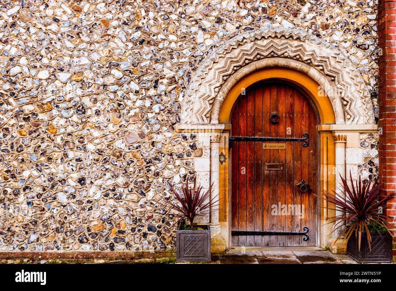 Casa dell'Arcidiaconio, con porta ad arco semicircolare e muro di selce. Chichester Cathedral, Canon Lane, Chichester, West Sussex, South East, Inghilterra, uni Foto Stock