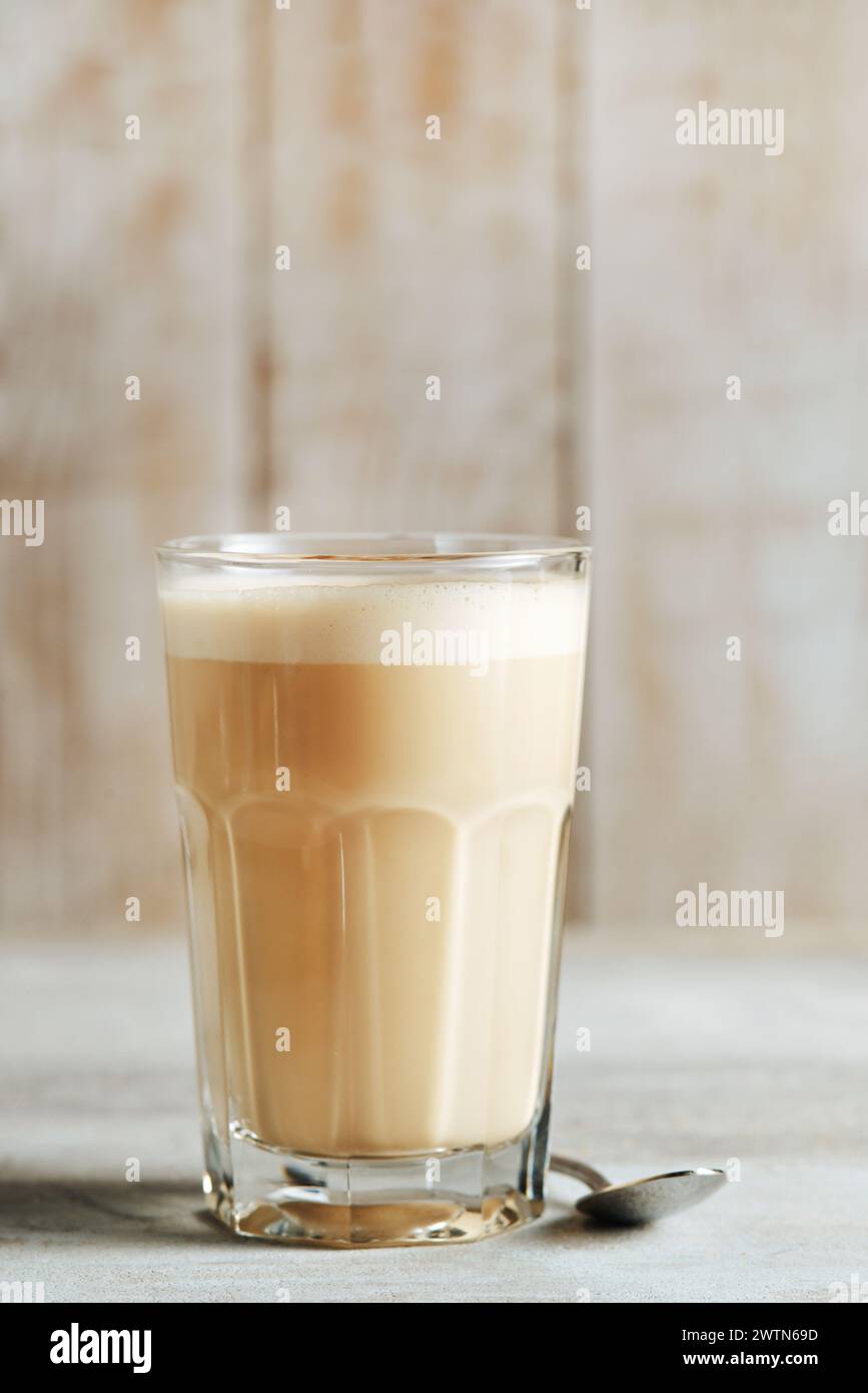 Caffè Raff in vetro trasparente su sfondo di legno chiaro. caffè con latte. Foto Stock
