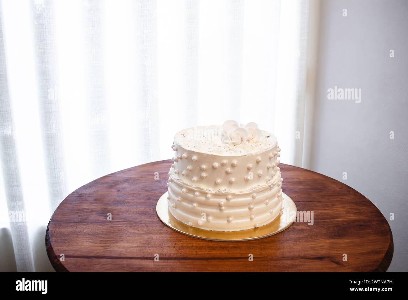 Torta bianca per feste con glassa bianca e perle, design per torte. Torta fatta a mano per un'occasione speciale. Copia spazio Foto Stock