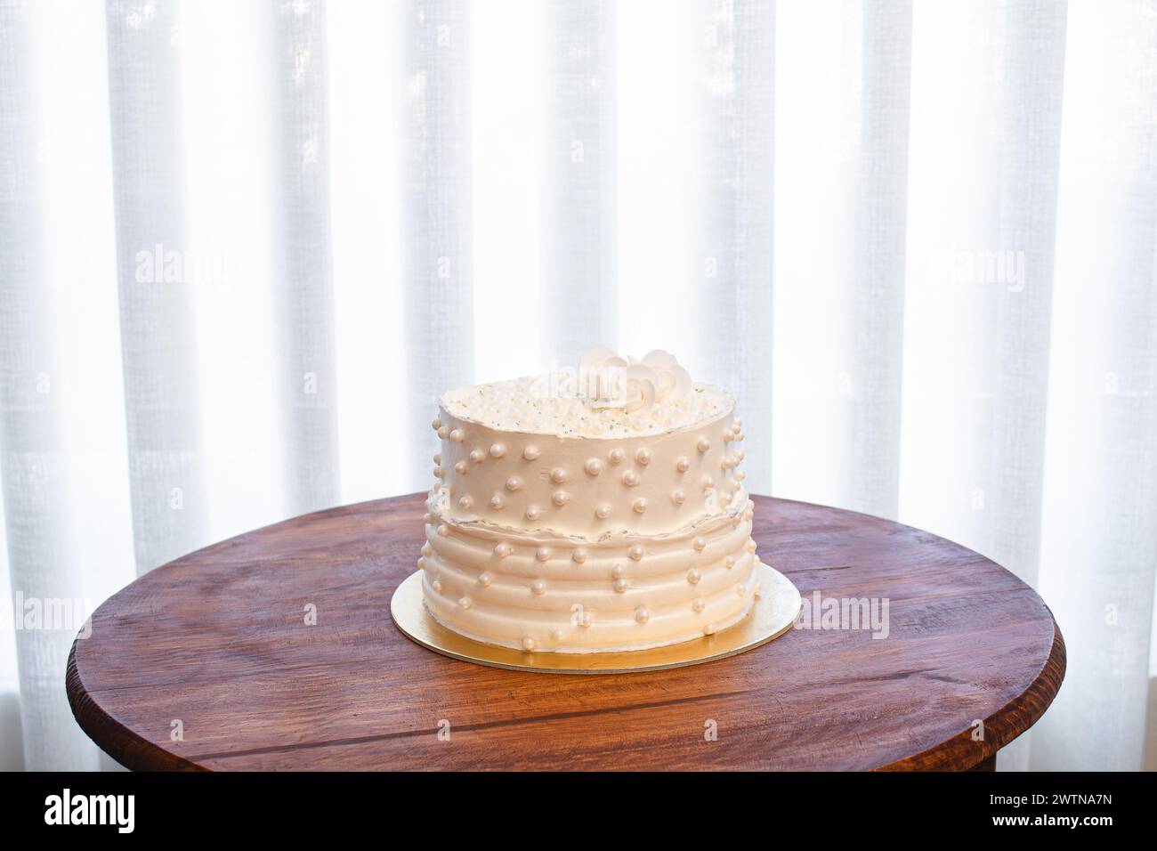 Torta bianca per feste con glassa bianca e perle, design per torte. Torta fatta a mano per un'occasione speciale. Copia spazio Foto Stock