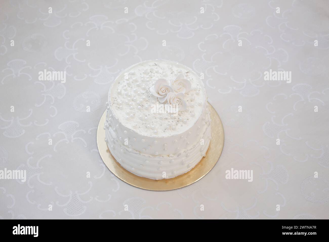 Torta bianca per feste con glassa bianca e perle, design per torte. Torta fatta a mano per un'occasione speciale. Copia spazio Foto Stock