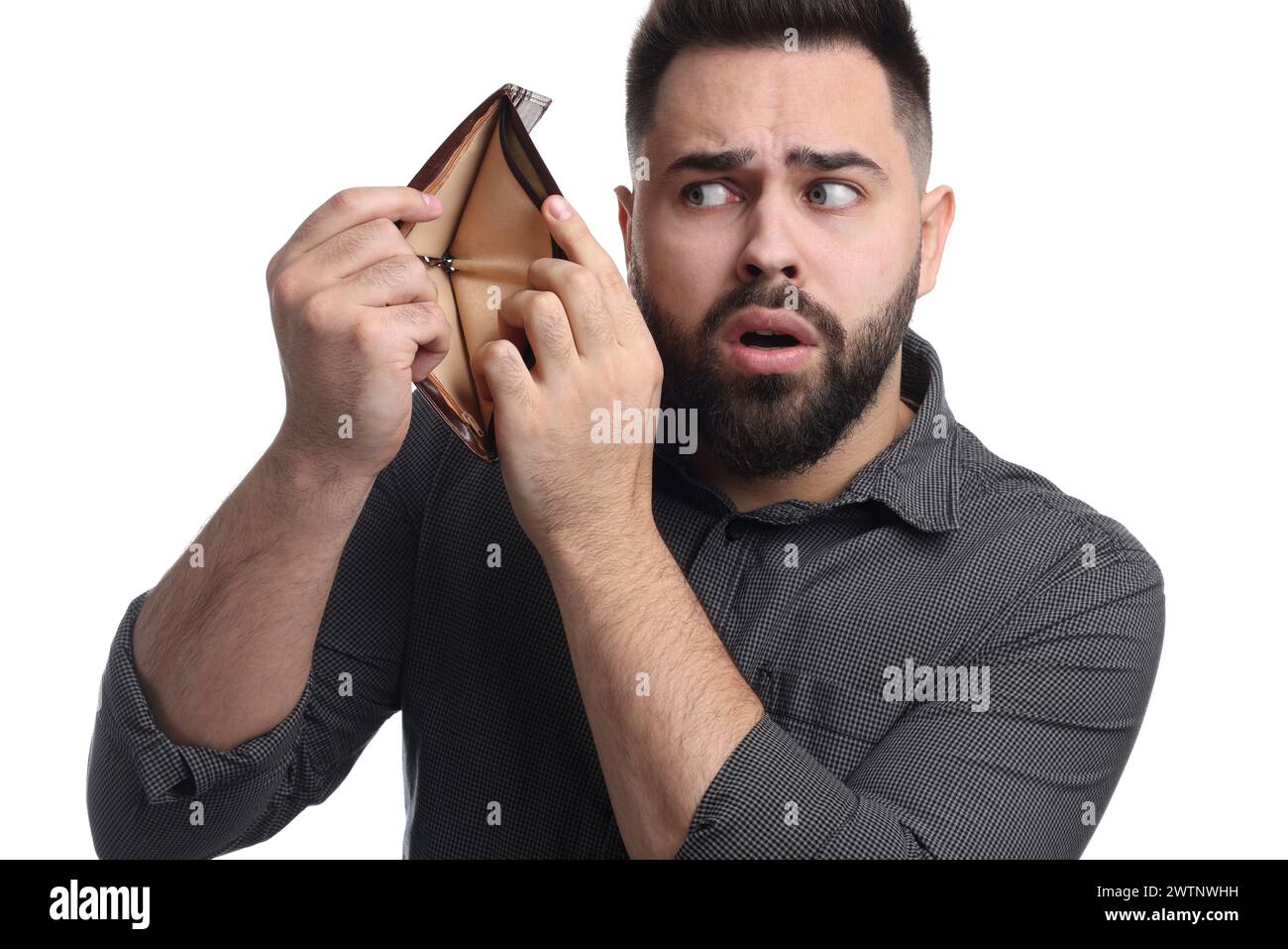 Uomo confuso che mostra un portafoglio vuoto su sfondo bianco Foto Stock