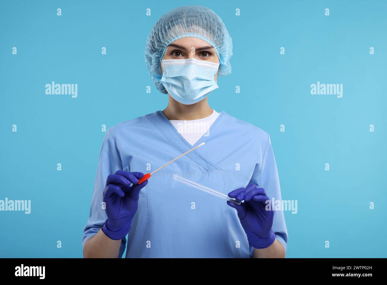 Analisi di laboratorio. Medico con tampone di cotone e provetta su sfondo azzurro Foto Stock