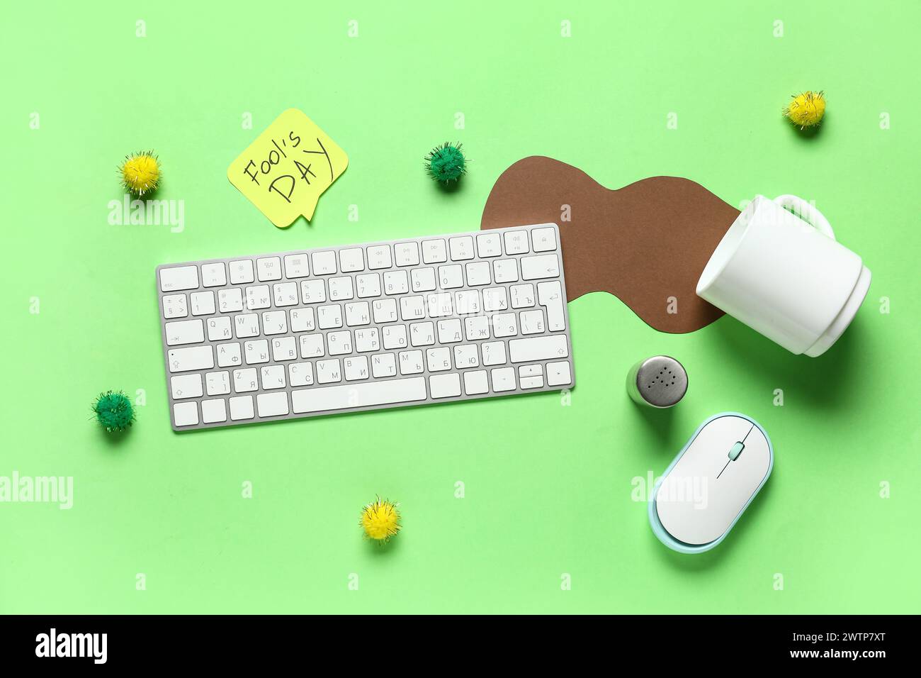 Tastiera del computer, note adesive e scherzo con una tazza di caffè rovesciata su sfondo verde. April Fools Day Pank Foto Stock