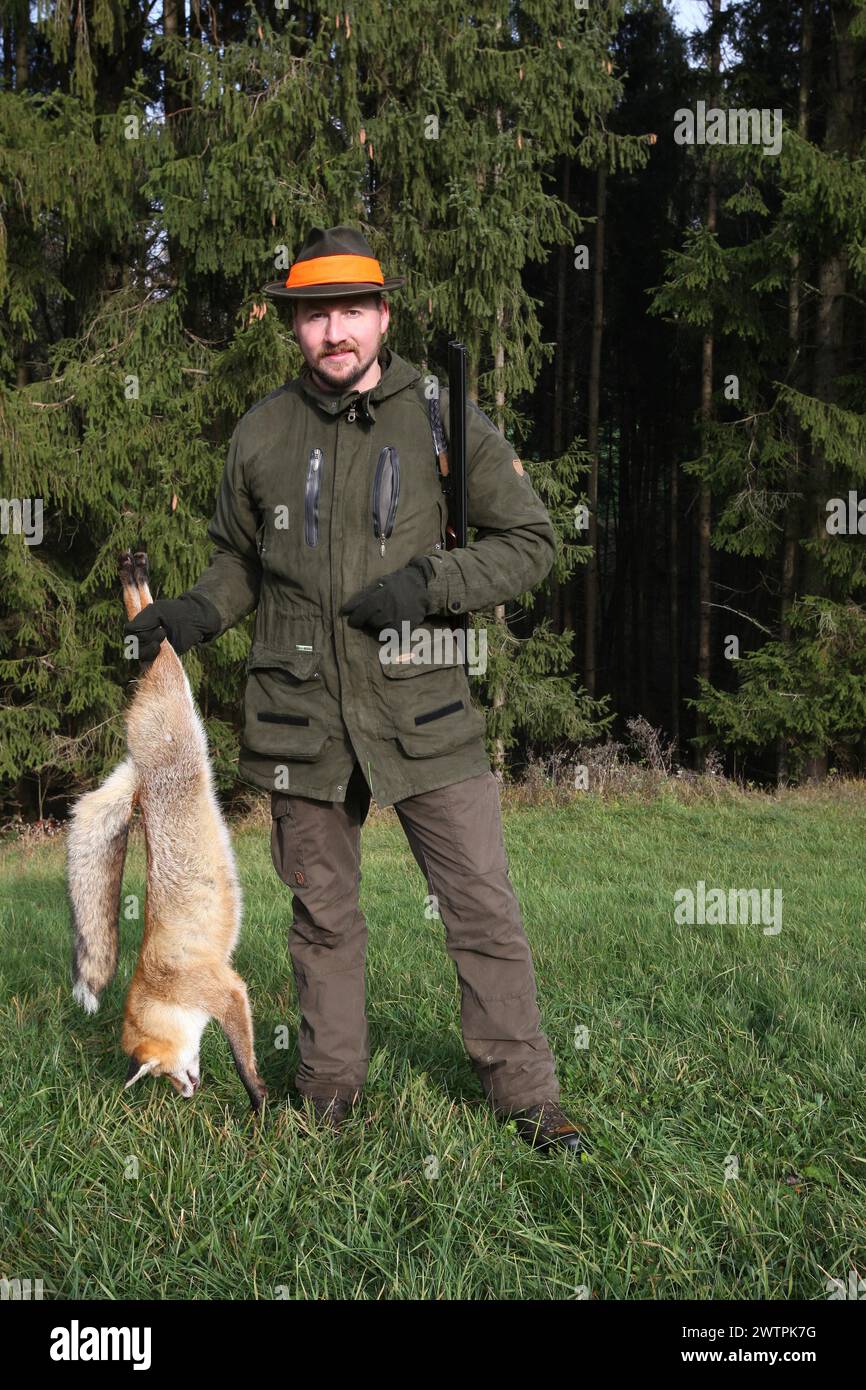 Cacciatore con una volpe rossa (Vulpes vulpes) sparato durante una caccia alle lepri brune (Lepus europaeus) bassa Austria, Austria Foto Stock