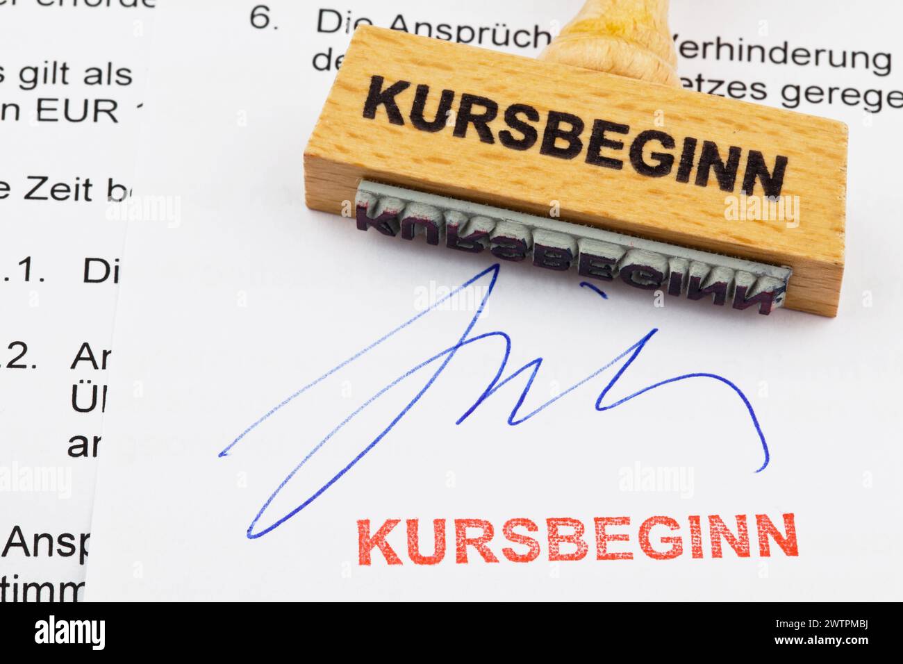 Un timbro di legno su un documento. Iscrizione tedesca: Kursbeginn Foto Stock