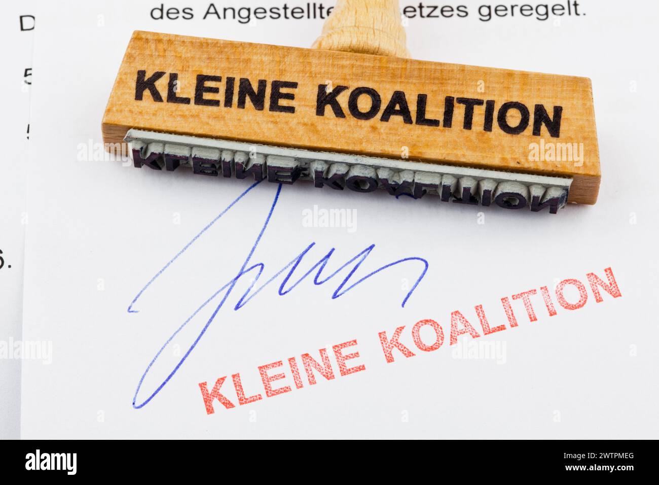 Un timbro di legno giace su un documento. Iscrizione tedesca: Kleine Koalition Foto Stock