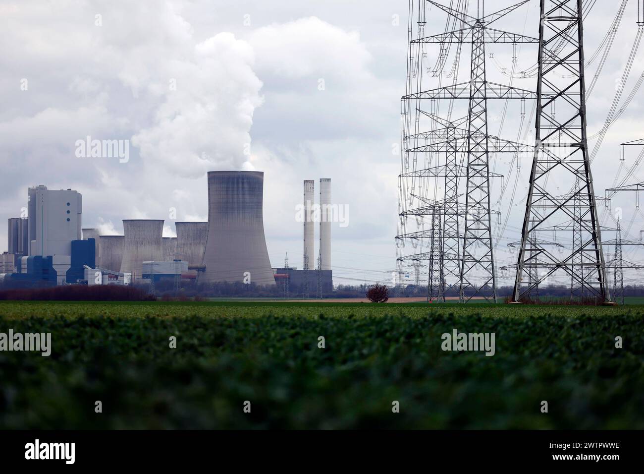 Strommasten und Windräder rund um das Kohlekraftwerk Niederaußem des Stromkonzerns RWE. Themenbild, Symbolbild. Bergheim, 18.03.2024 NRW Deutschland *** tralicci elettrici e turbine eoliche intorno alla centrale elettrica a carbone RWEs Niederaussem immagine a tema, immagine simbolica Bergheim, 18 03 2024 NRW Germania Copyright: XChristophxHardtx Foto Stock