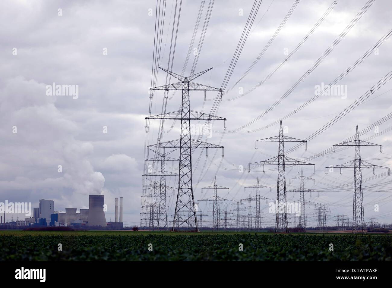 Strommasten und Windräder rund um das Kohlekraftwerk Niederaußem des Stromkonzerns RWE. Themenbild, Symbolbild. Bergheim, 18.03.2024 NRW Deutschland *** tralicci elettrici e turbine eoliche intorno alla centrale elettrica a carbone RWEs Niederaussem immagine a tema, immagine simbolica Bergheim, 18 03 2024 NRW Germania Copyright: XChristophxHardtx Foto Stock