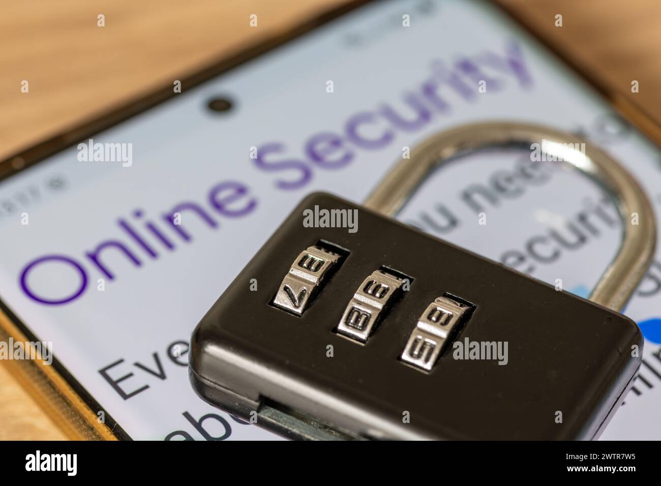 Un lucchetto a combinazione sulla parte superiore di uno smartphone con le parole sicurezza online. Un concetto di sicurezza online. Foto Stock