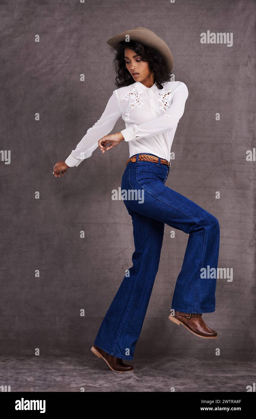 Abiti da donna, moda e western in studio, stile selvaggio West e country su modello indiano. Una donna forte e sicura di sé con un cappello alla moda Foto Stock