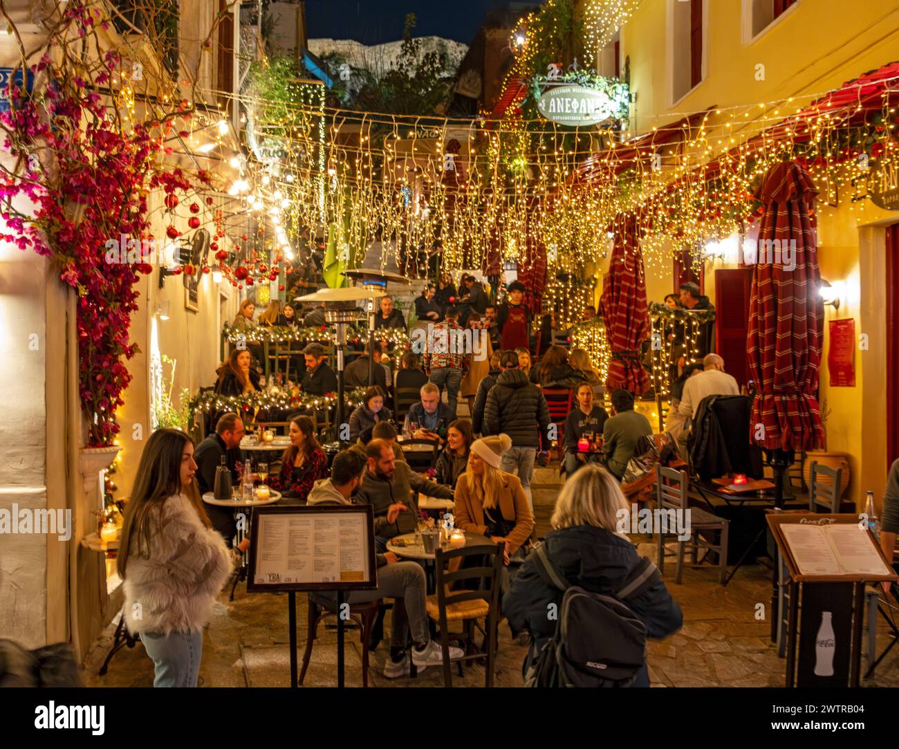 La gente si riunisce ai tavoli dei ristoranti più famosi di notte, Mnisikleous Street Scales, Plaka, Atene, Grecia Foto Stock