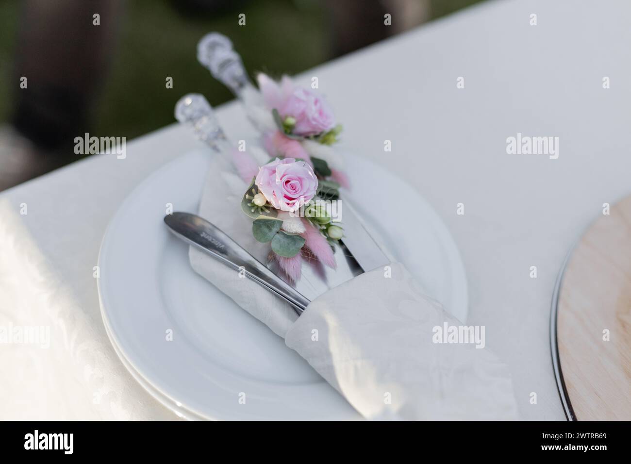 Stoviglie elegantemente arredate con dettagli floreali per un ricevimento di nozze. Perfetto per catering, organizzazione di eventi e temi di ospitalità Foto Stock