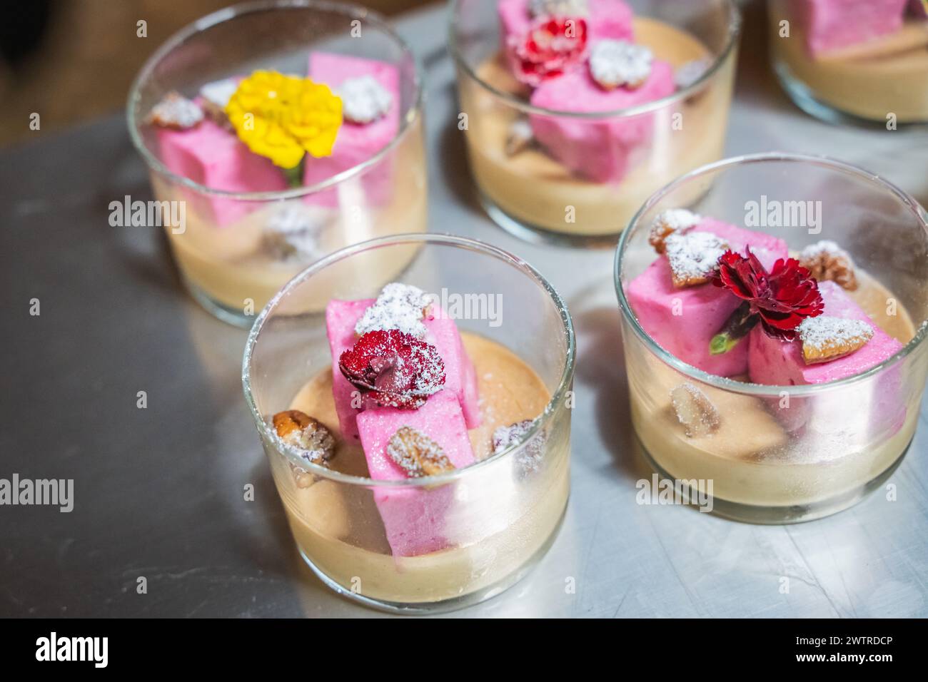 Dessert assortiti in tazze condite con frutta vibrante in mostra Foto Stock