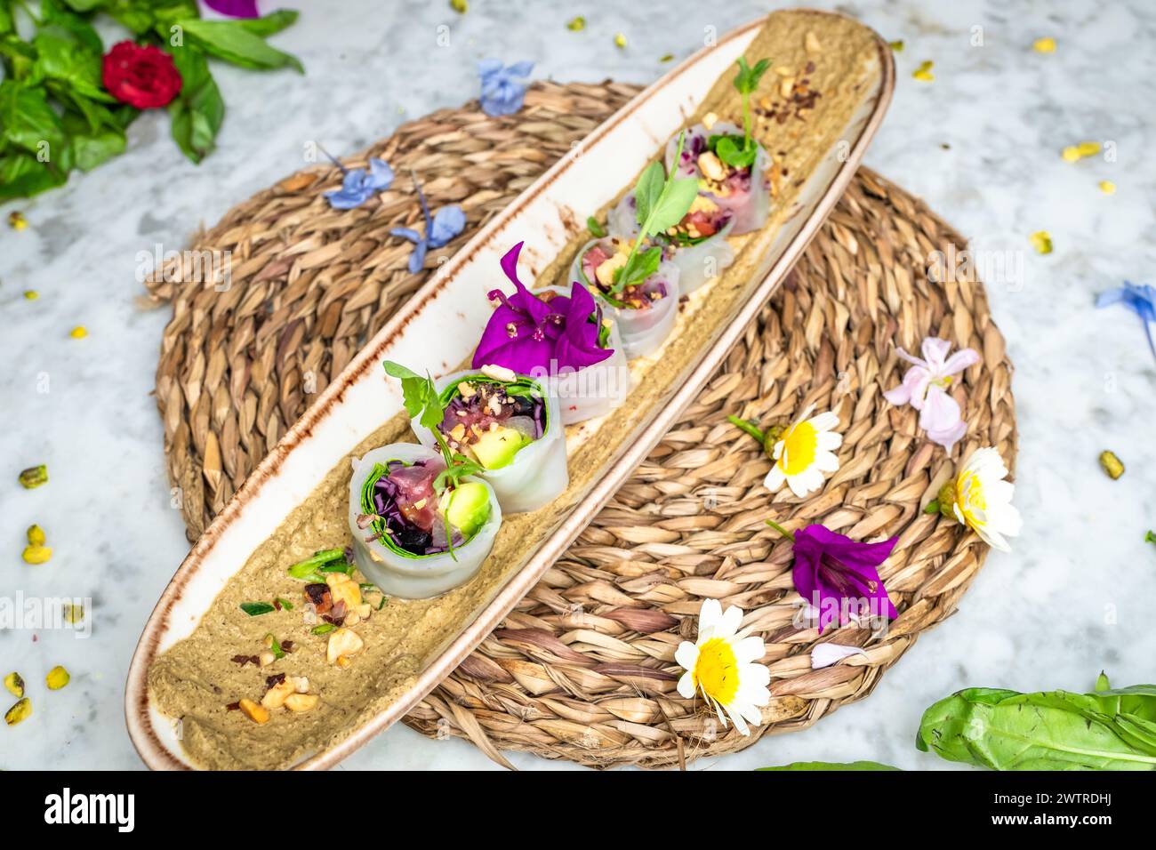 I sushi vegani con avocado su un piatto guarnito con piccoli fiori Foto Stock