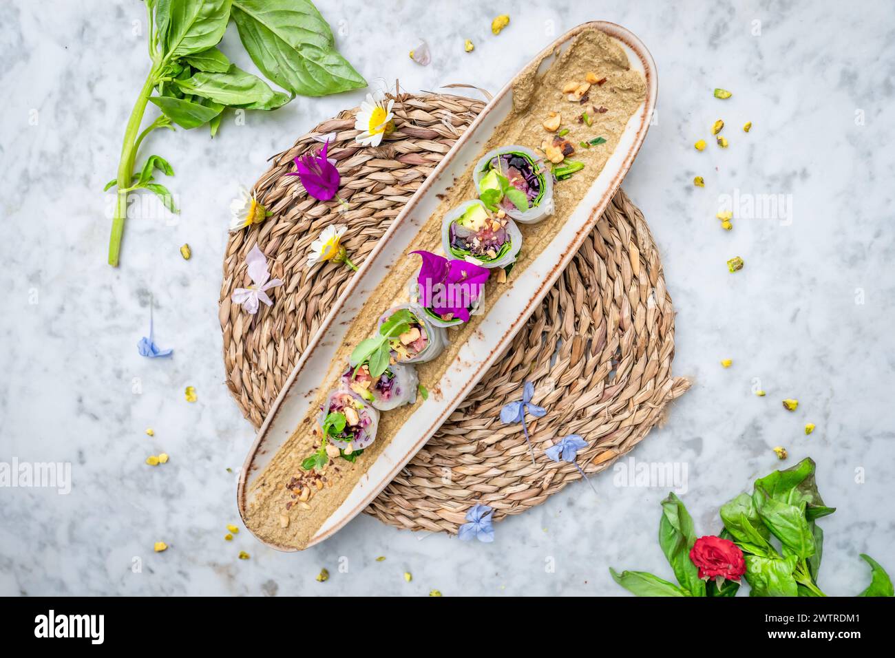 I sushi vegani con avocado su un piatto guarnito con piccoli fiori Foto Stock