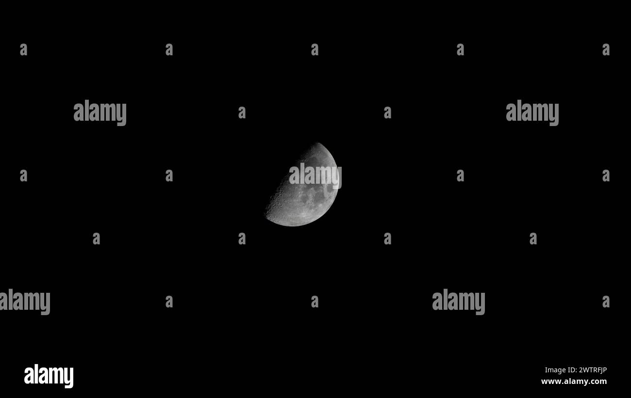 Il primo quarto di luna (mezzaluna) nel marzo 2024 con uno sfondo di cielo nero preso dall'Alberta, Canada Foto Stock