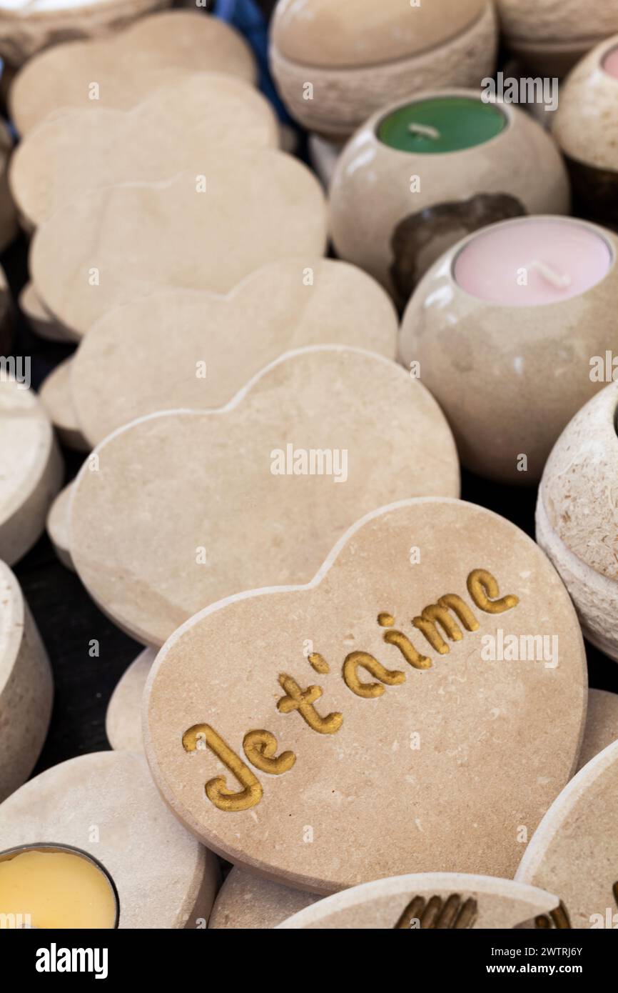 Cuori di pietra scolpiti in vendita in un mercato che dice "ti amo" in francese Je t'aime Foto Stock