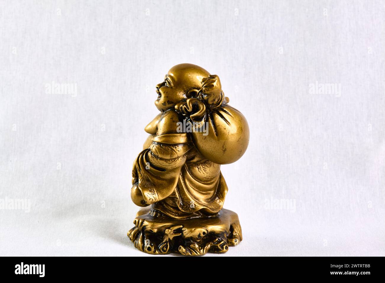Statuetta in bronzo di Buddha che cammina con una borsa sulla spalla, vista laterale, souvenir Foto Stock