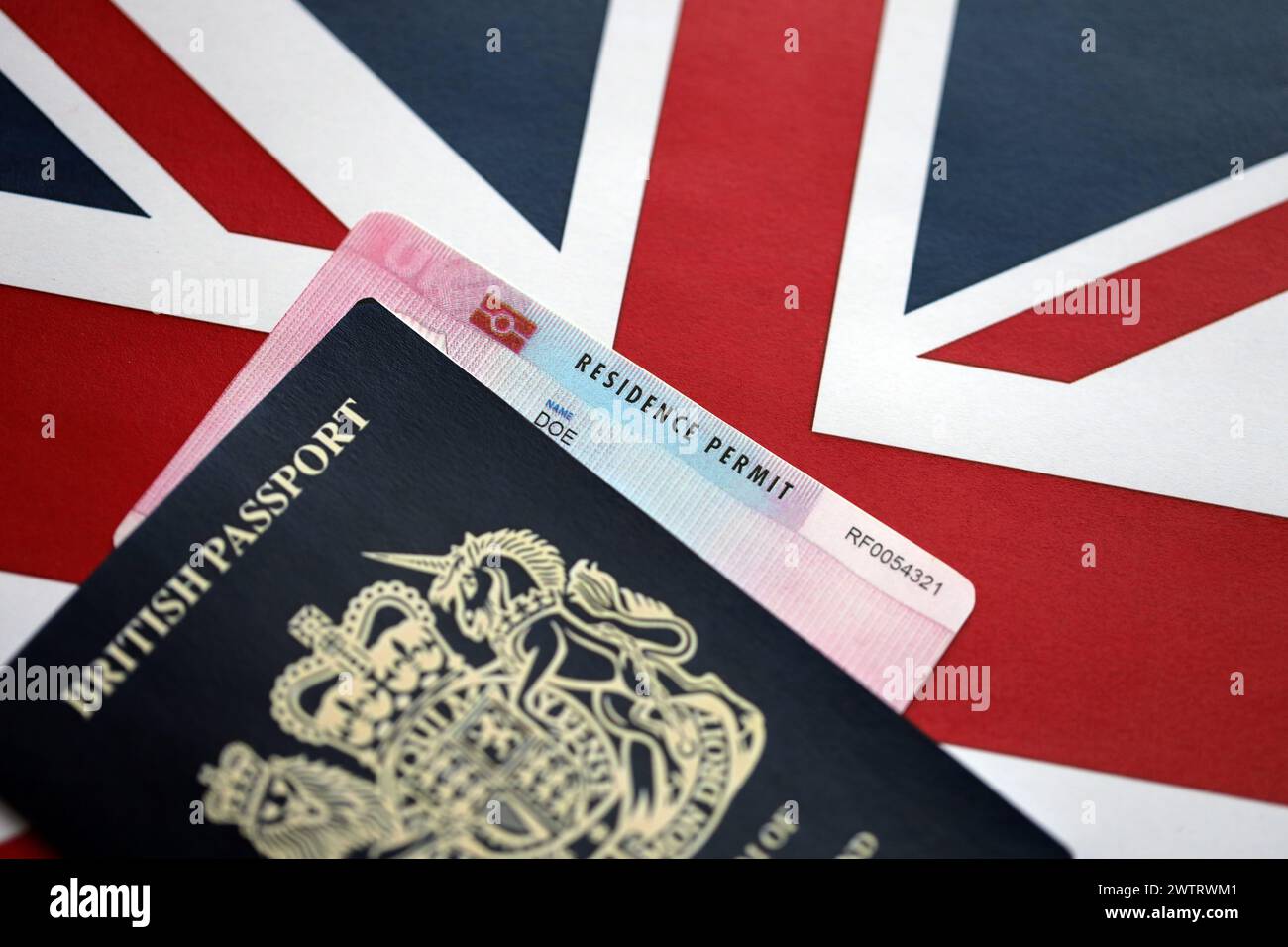 Permesso di soggiorno carta BRP e passaporto britannico del Regno Unito con la bandiera Union Jack primo piano Foto Stock