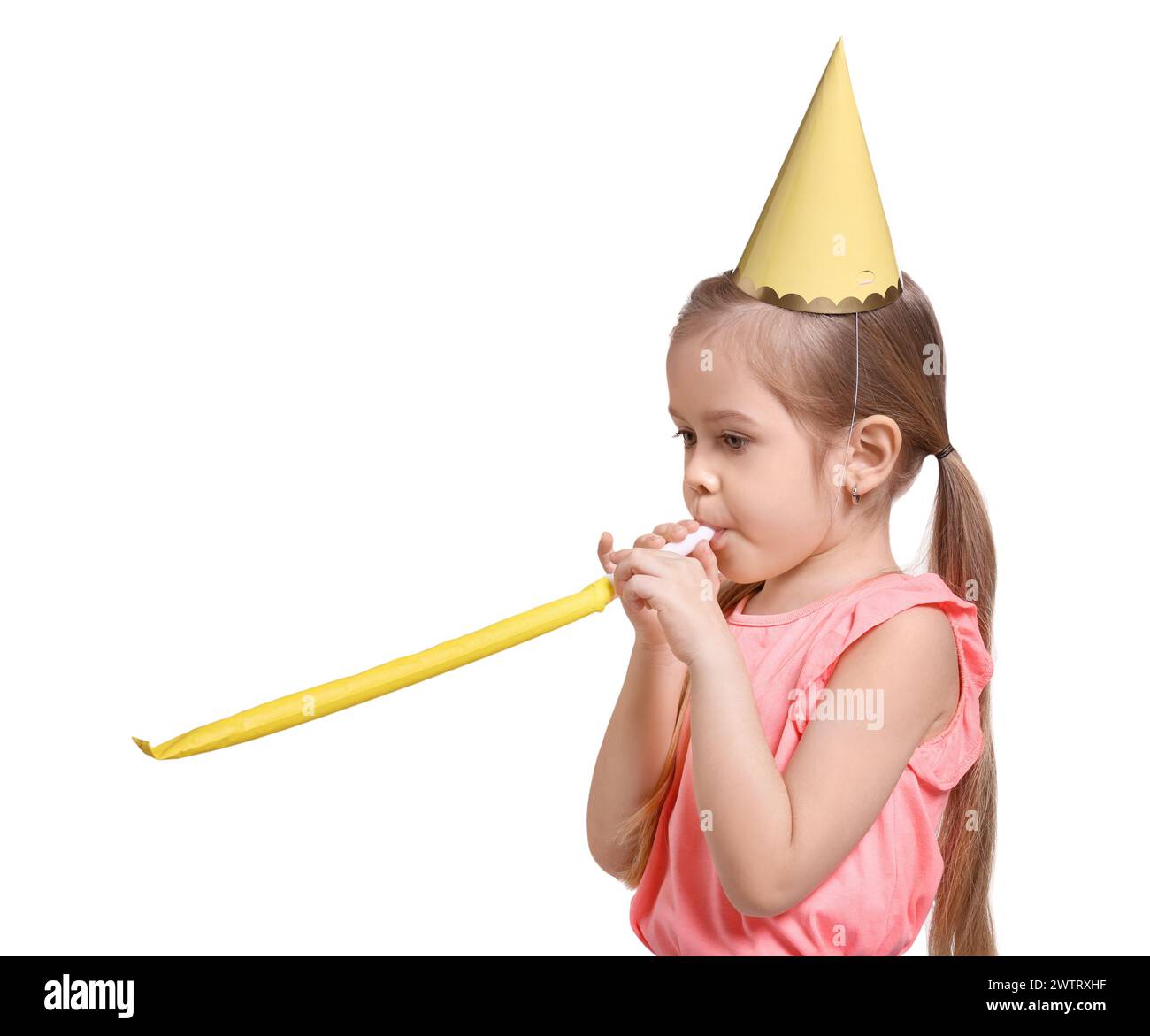 Festa di compleanno. Simpatica bambina con cappello da festa con soffiatore su sfondo bianco Foto Stock