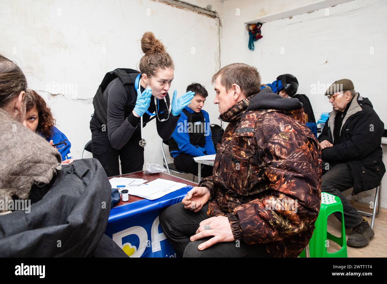 Chasiv Yar, regione di Donetsk, Ucraina. 9 marzo 2024. Un medico volontario della missione Frida Ucraina è visto dare consigli a un uomo in cerca di assistenza medica. FRIDA Ucraina è una missione Ucraina-israeliana di volontari medici volti ad aiutare la popolazione civile. I medici volontari forniscono agli ucraini colpiti dalle ostilità medicine di alta qualità e organizzano viaggi in prima linea nelle regioni deoccupate per aiutare i civili che vivono lì. Questo lavoro di volontariato è iniziato nella regione di Kiev, seguito da Chernihiv, Sumy, Charkiv, Mykolaiv, Kherson, Donetsk e altre regioni dove i civili Foto Stock