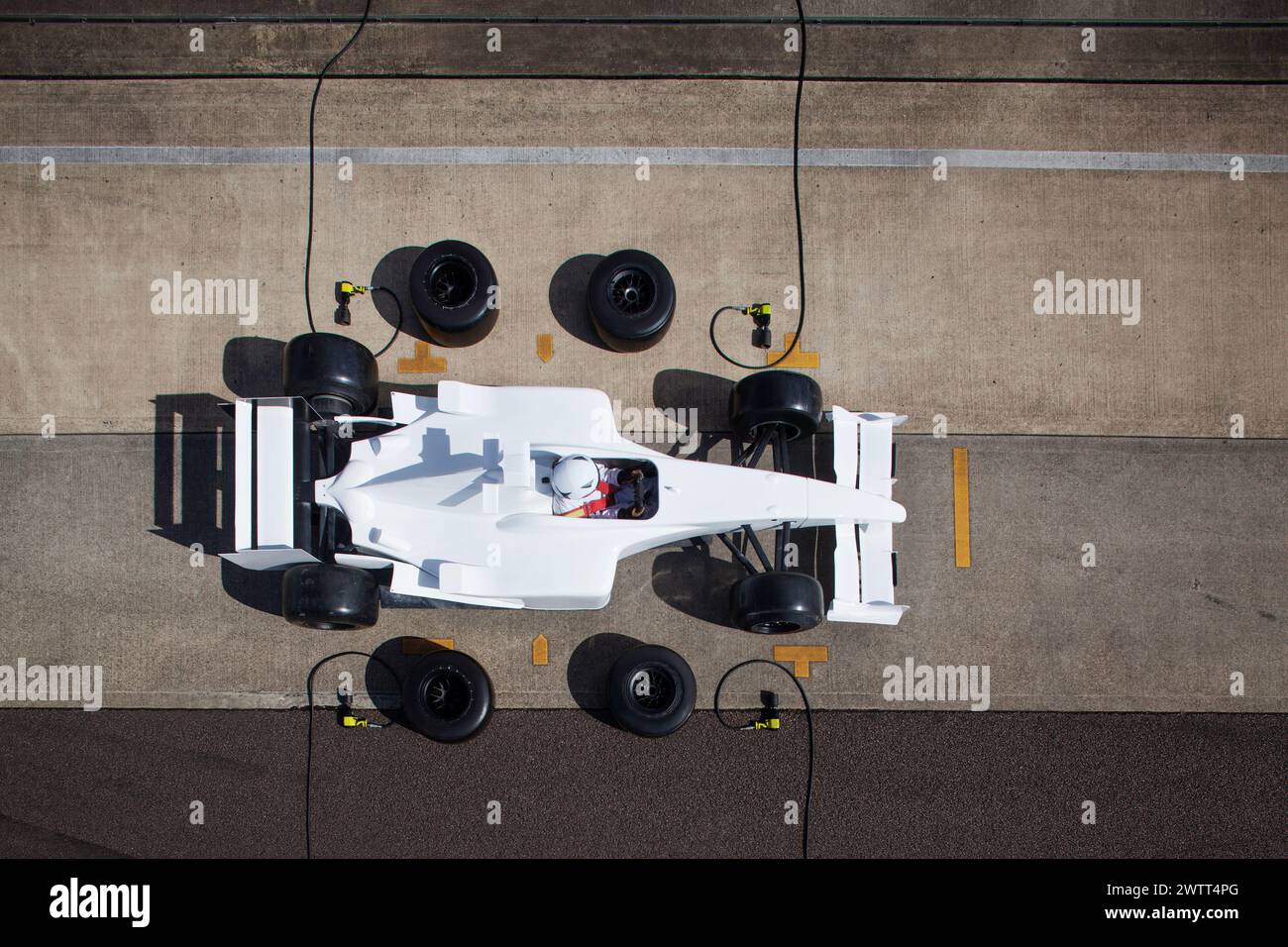 Vista aerea di un pit stop per auto da corsa con equipaggio e pilota in azione Foto Stock