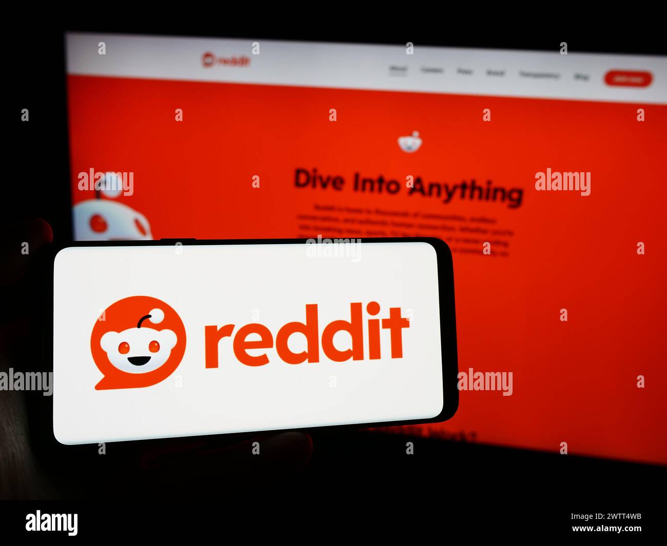 Persona che detiene un telefono cellulare con il logo della società americana di social media Reddit Inc. Di fronte alla pagina Web aziendale. Mettere a fuoco il display del telefono. Foto Stock