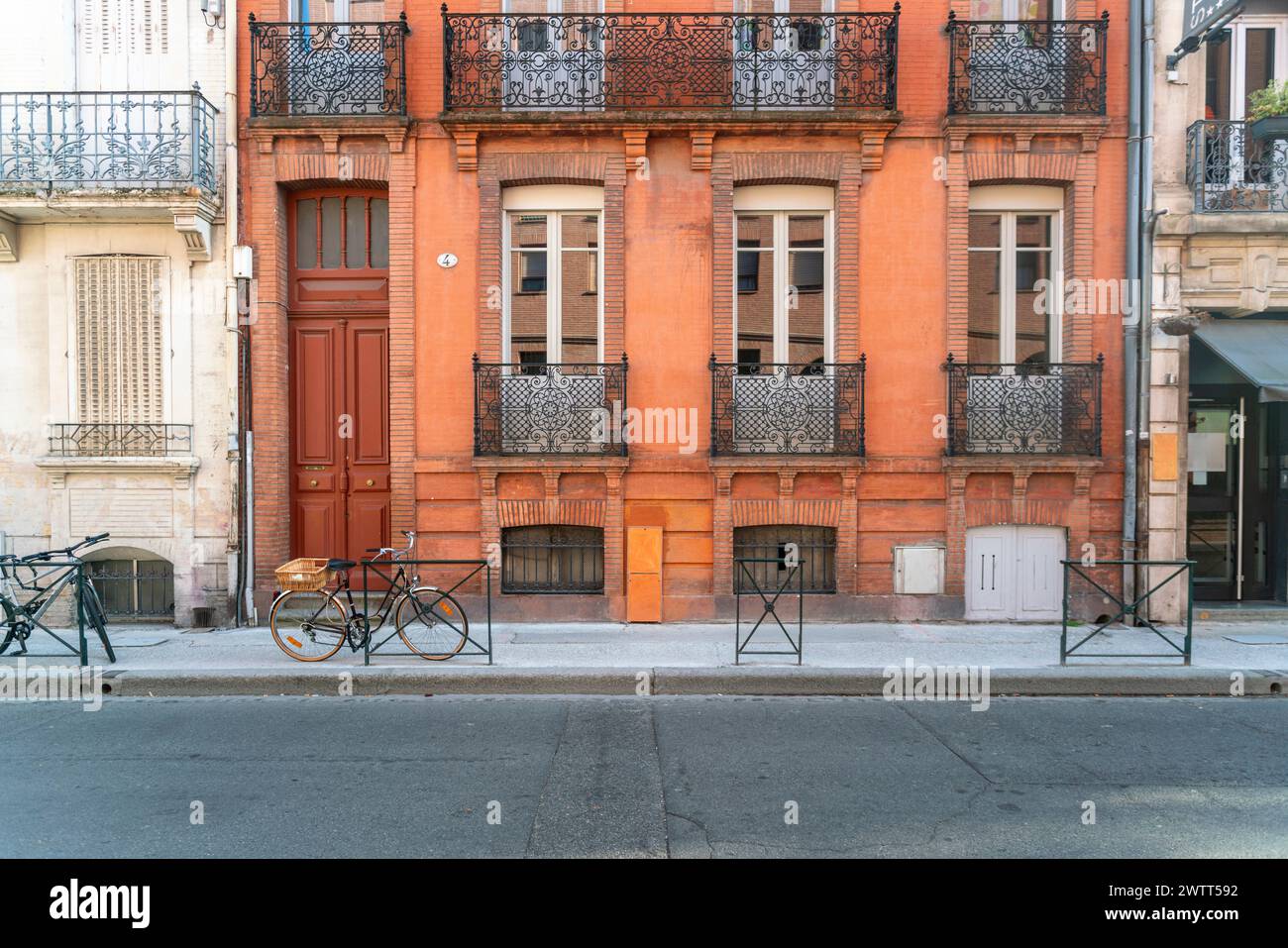 Facciata o esterno di storiche case tradizionali in rosso o arancione nella città vecchia di Tolosa, in Francia Foto Stock