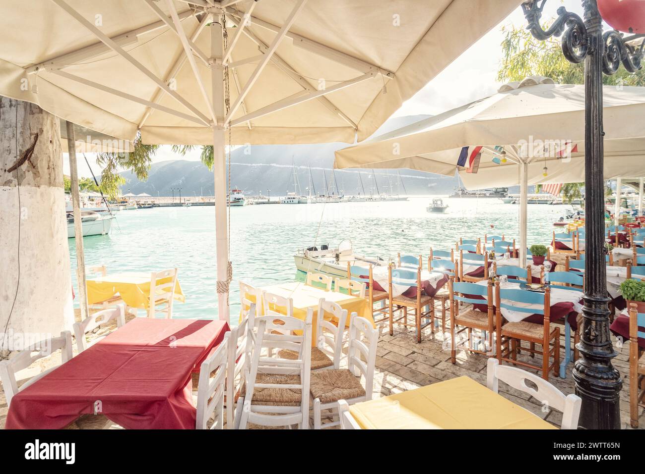Baia di Vassiliki in una giornata di primavera soleggiata con taverna e caffetterie sull'isola di Lefkada Foto Stock