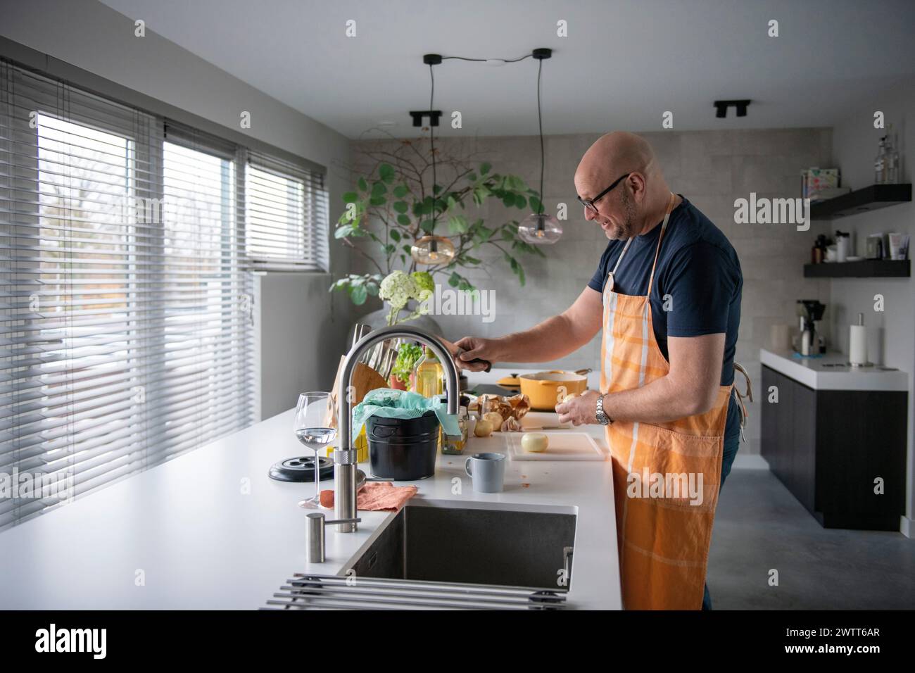 Uomo che prepara la colazione in una cucina moderna Foto Stock