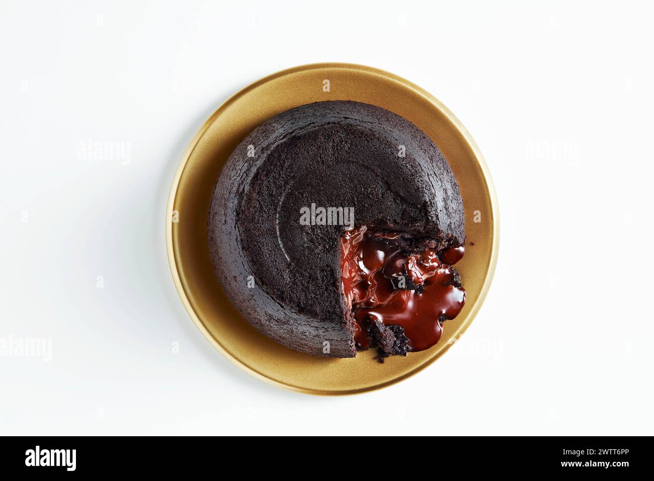 Una deliziosa torta lavica al cioccolato con un centro fuso su un piatto dorato. Foto Stock