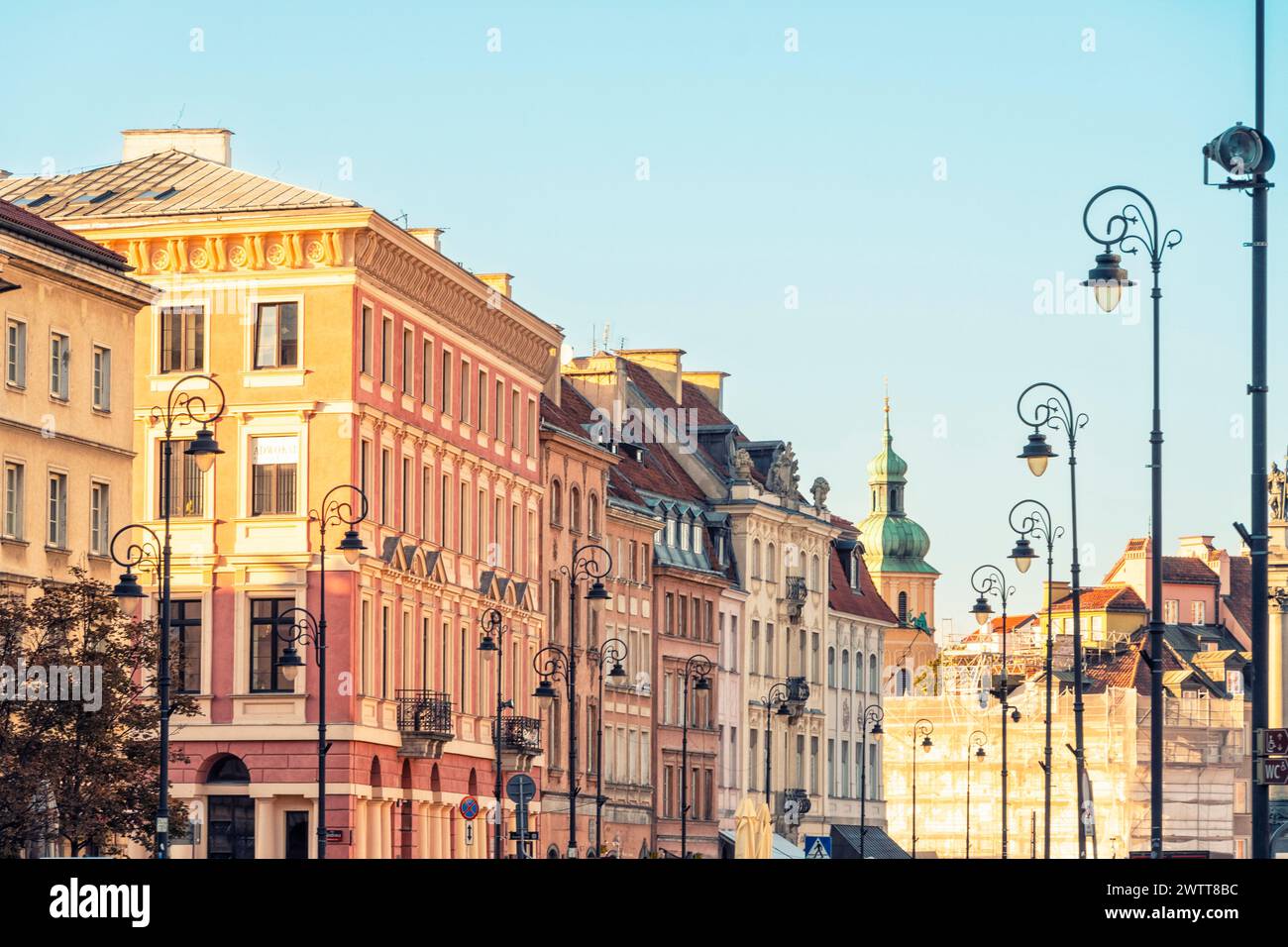 La calda luce del tramonto proietta una luce soffusa su una pittoresca fila di edifici storici europei Foto Stock