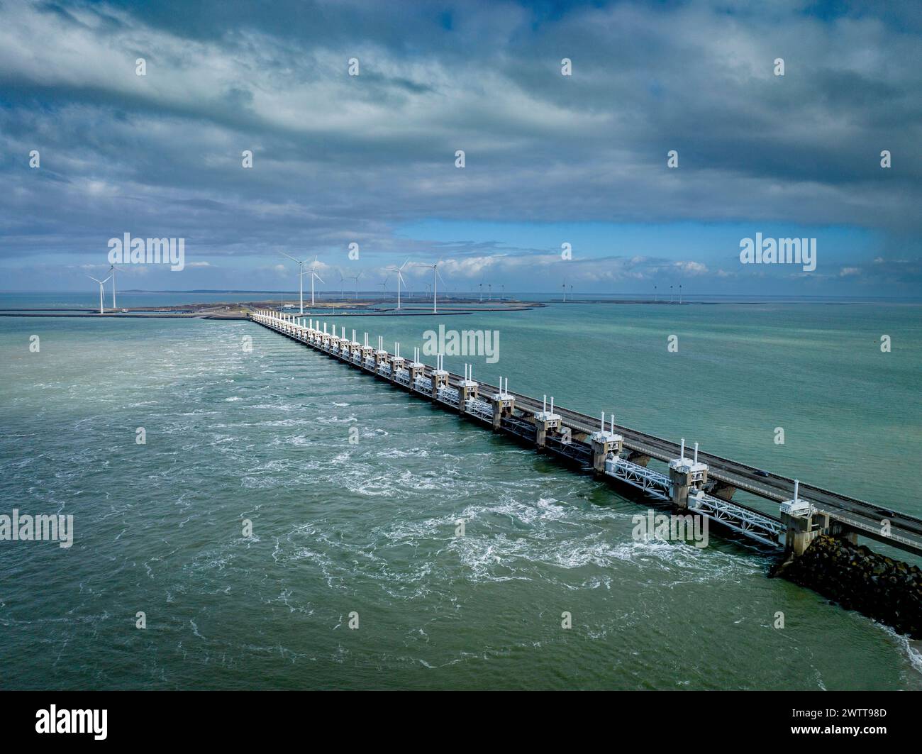 Una vista tranquilla di un lungo molo che si estende in un mare calmo sotto un cielo nuvoloso. Foto Stock
