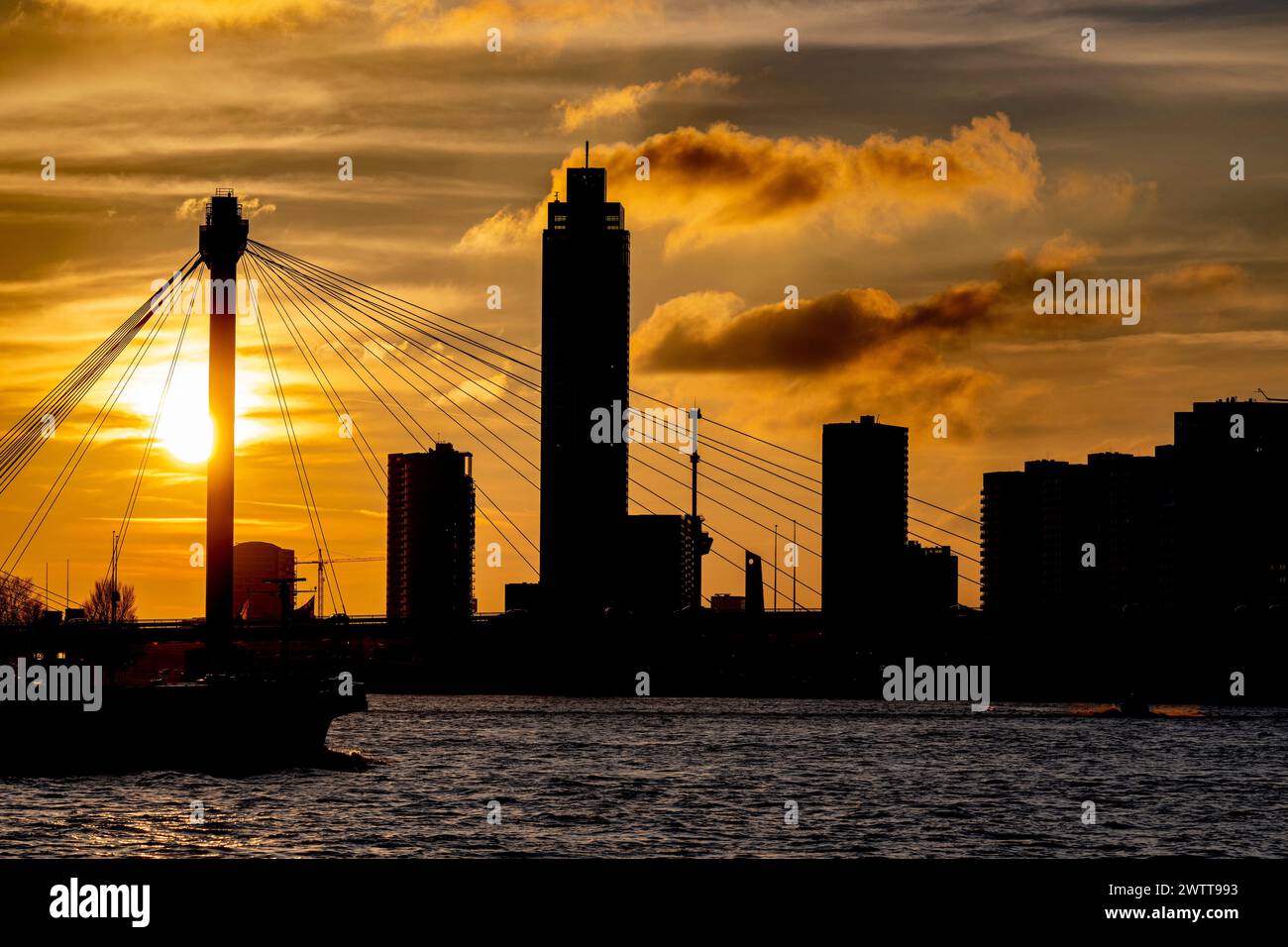 Un tramonto sereno che delinea un paesaggio urbano con un ampio ponte strapiombo Foto Stock